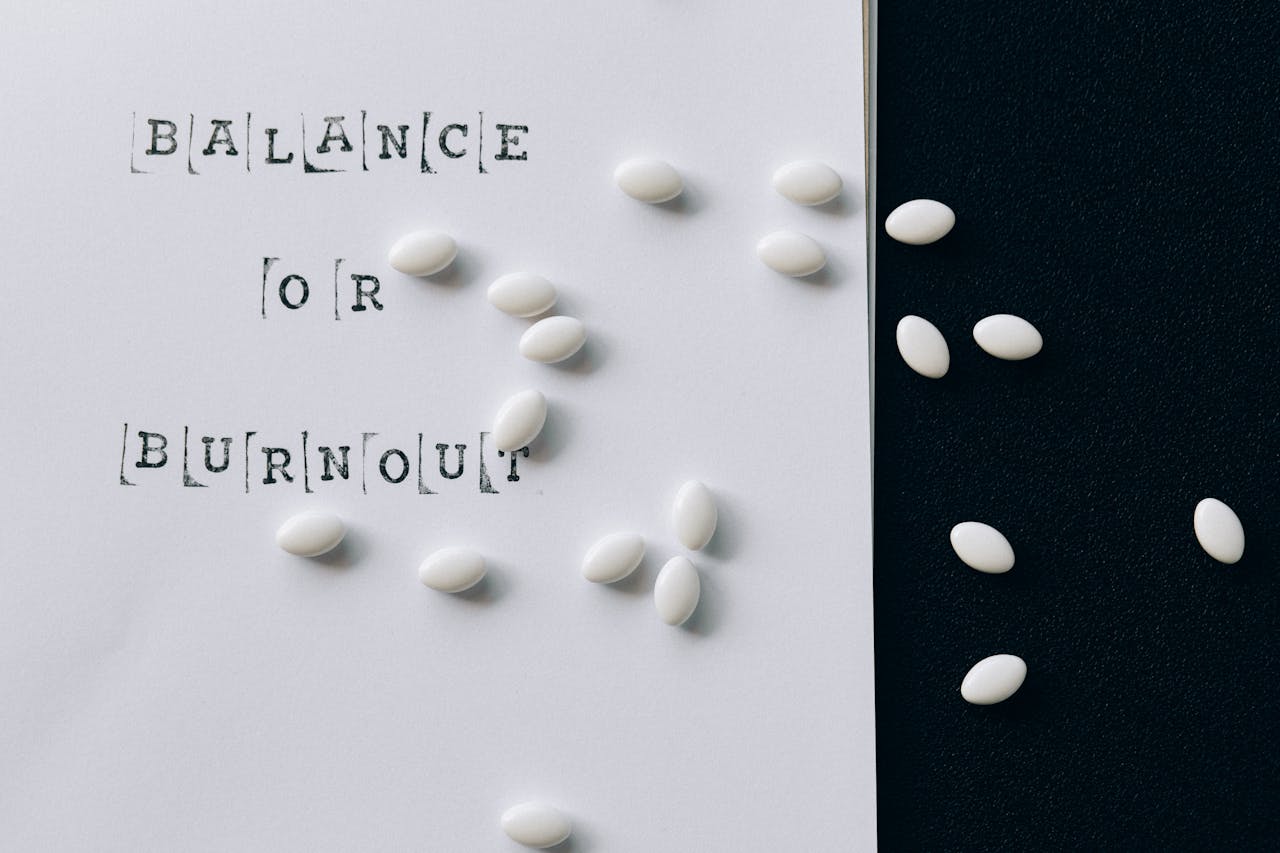 Conceptual image featuring 'Balance or Burnout' text with scattered white capsules.